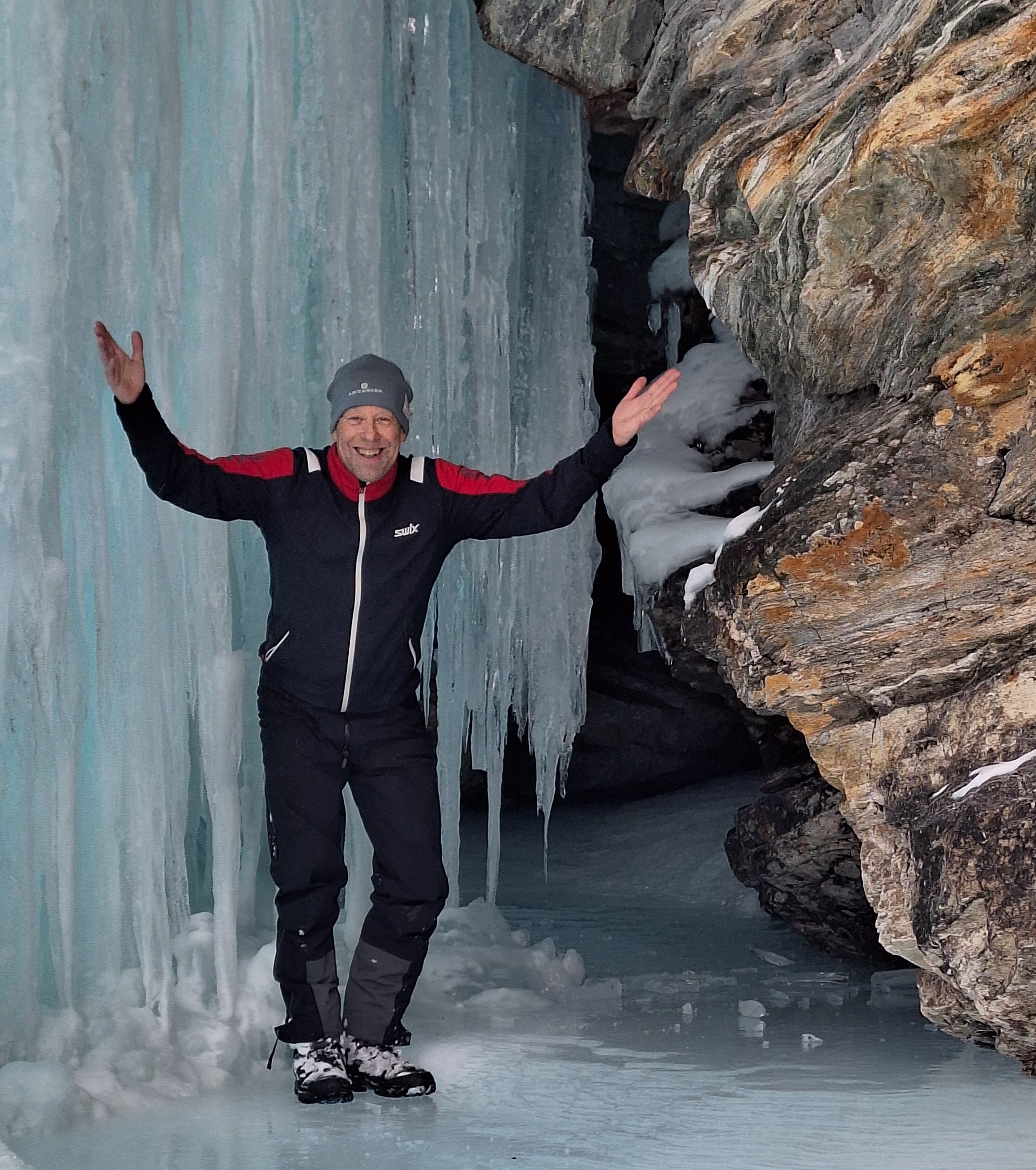 Person vor einem gefrorenen Wasserfall